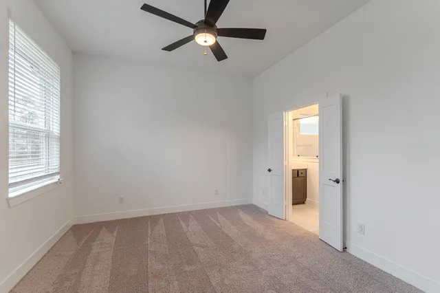 an empty room with a window and a fan