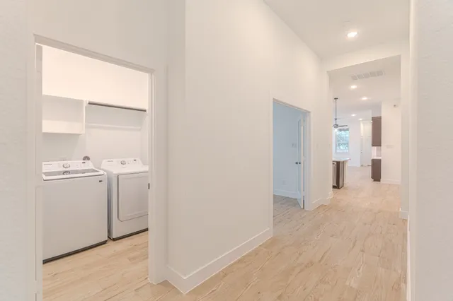 a view of a hallway with closet and wooden floor