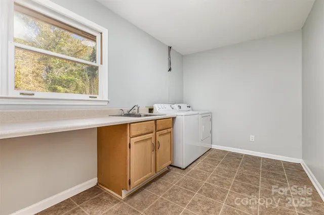 a view of an empty room with cabinet and a window