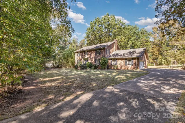 a view of a house with yard and a tree