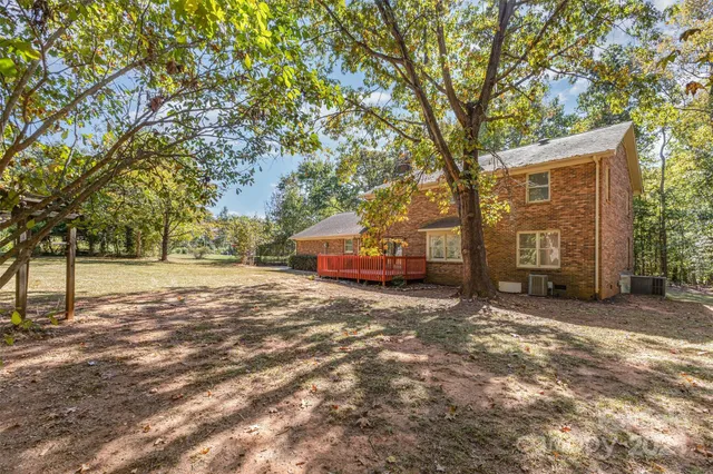 a view of backyard with wooden fence and a tree