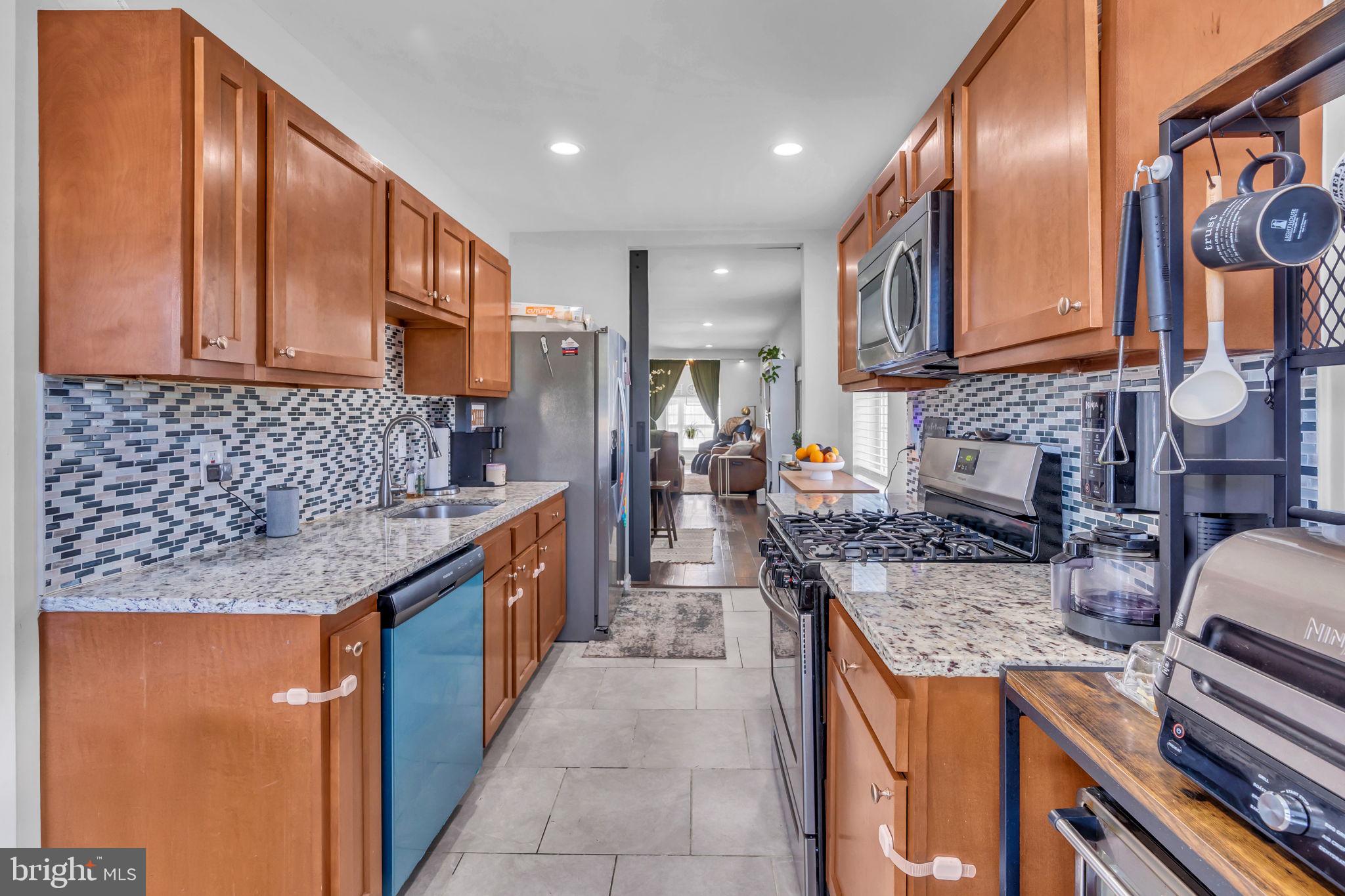 4908 1/2 Harford Road Baltimore, MD 21214 - Photo 7 of 20 a kitchen with stainless steel appliances granite countertop a sink stove and cabinets