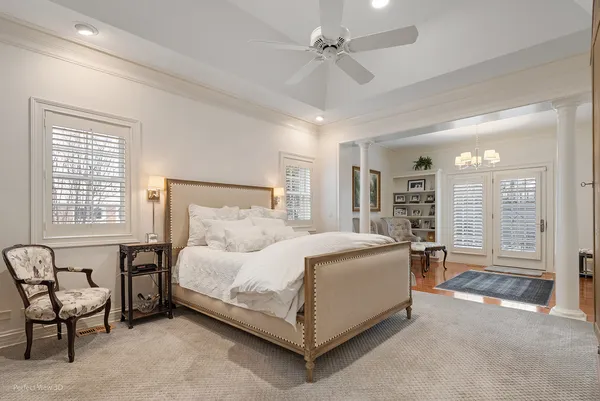 a spacious bedroom with a bed a table and chair