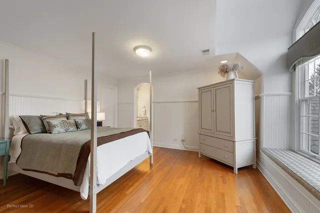 a bedroom with a bed and a large window