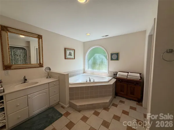 a bathroom with a bathtub sink and mirror