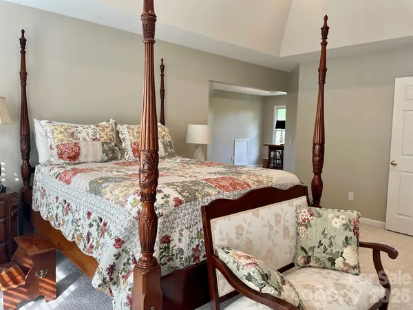 a bed sitting in a bedroom next to a window with a chandelier