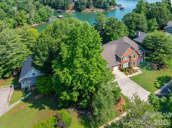 an aerial view of residential house with outdoor space and trees all around