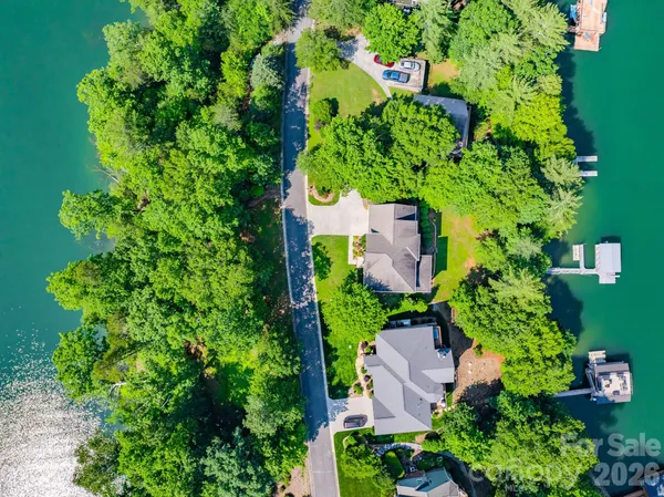 an aerial view of residential house with outdoor space and trees all around