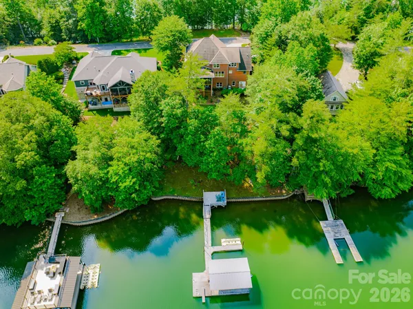 an aerial view of a house with swimming pool a yard and lake view