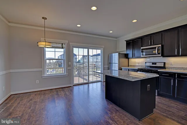 a kitchen with stainless steel appliances granite countertop a stove a sink a refrigerator and a microwave