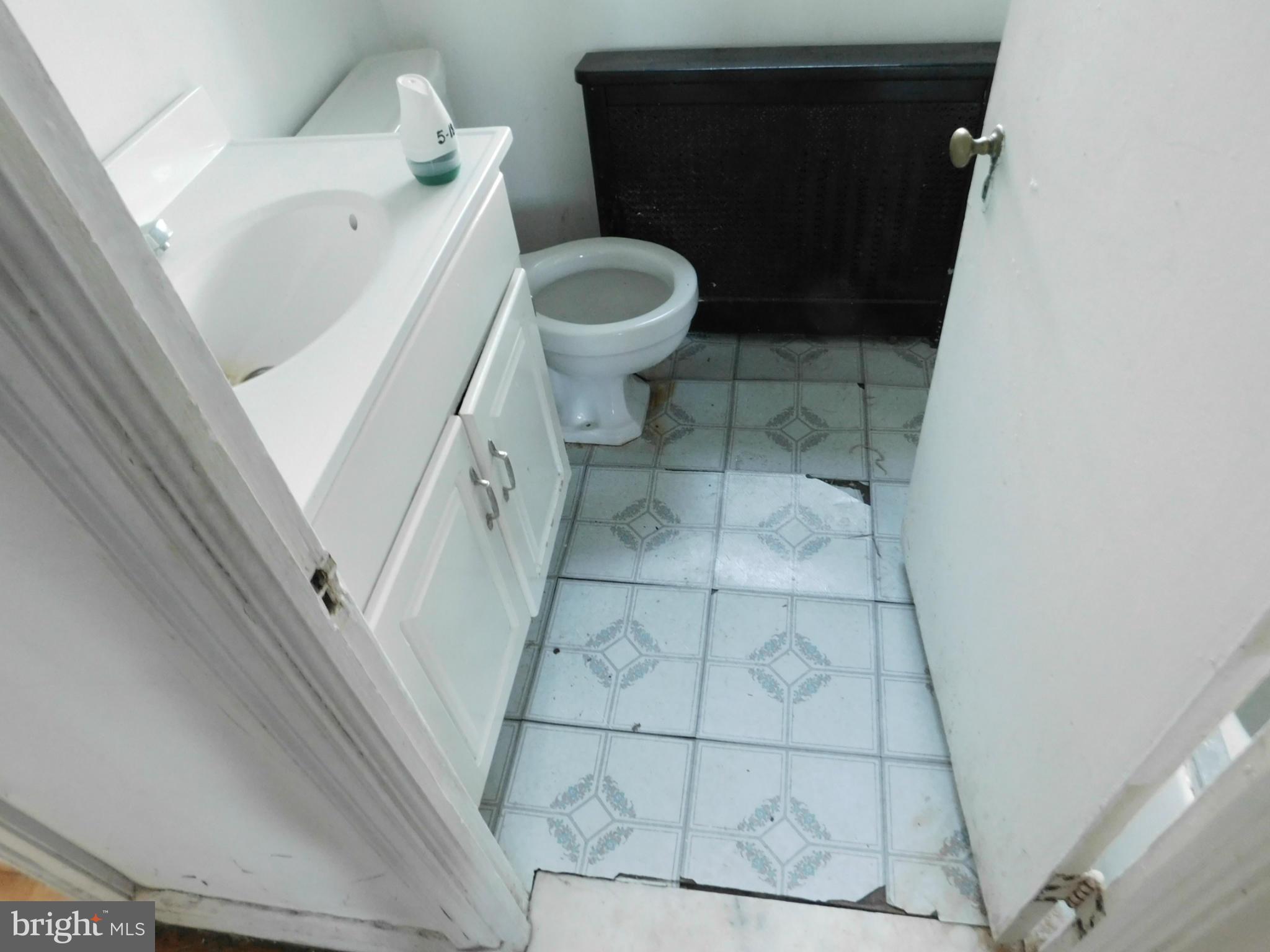 8401 Liberty Road Baltimore, MD 21244 - Photo 24 of 28 a white toilet sitting next to a white sink and vanity