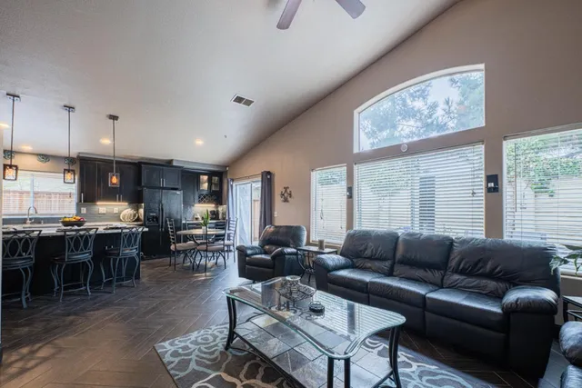 a living room with furniture a large window and a dining table