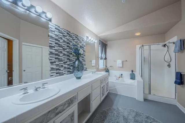 a spacious bathroom with double vanity sink a mirror and a shower