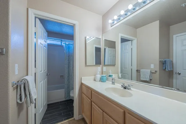 a bathroom with a double vanity sink a mirror and a shower