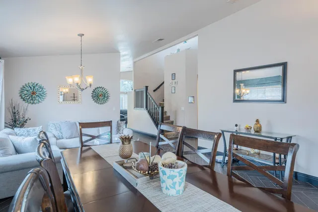 a view of a dining room with furniture a chandelier and wooden floor
