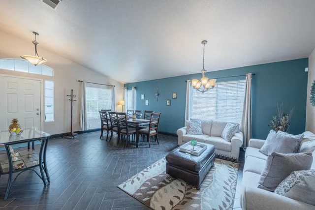a living room with furniture and a chandelier