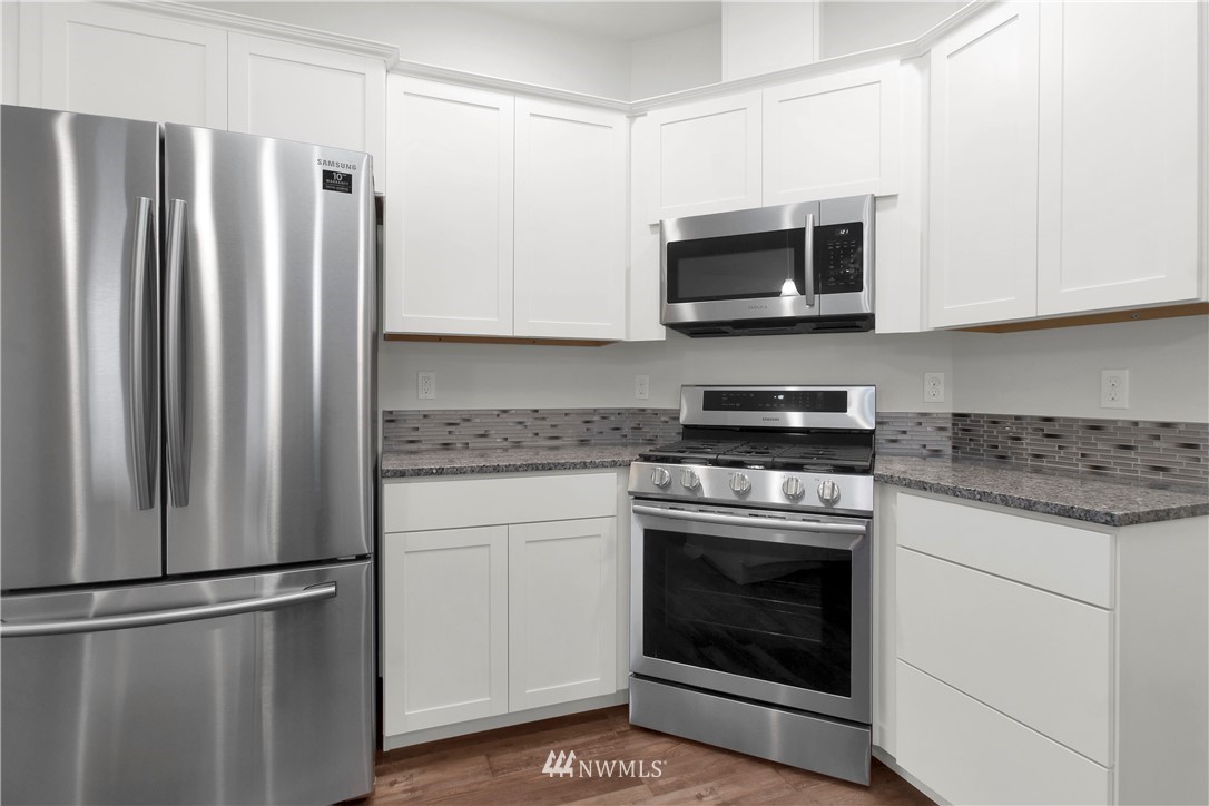674 Southwest 20th Street Chehalis, WA 98532 - Photo 9 of 29 a kitchen with stainless steel appliances granite countertop a stove a refrigerator and a microwave