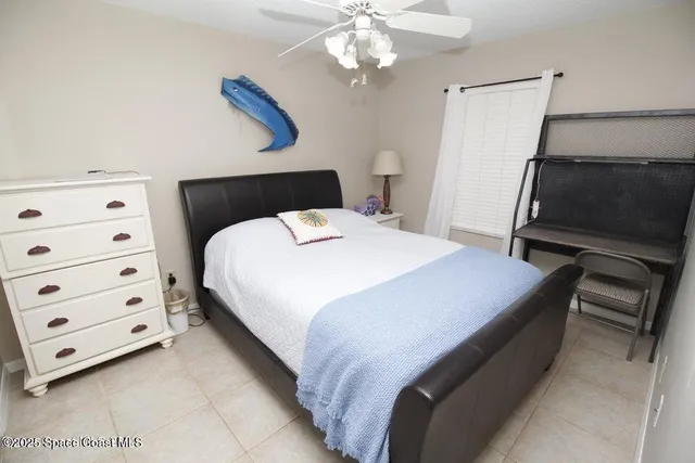 a bedroom with a bed and a flat tv screen on the dresser