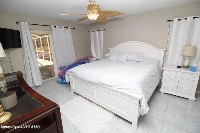 a bedroom with a bed and a flat tv screen on the dresser