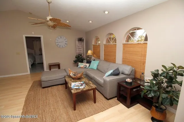 a living room with furniture flowerpot and a chandelier