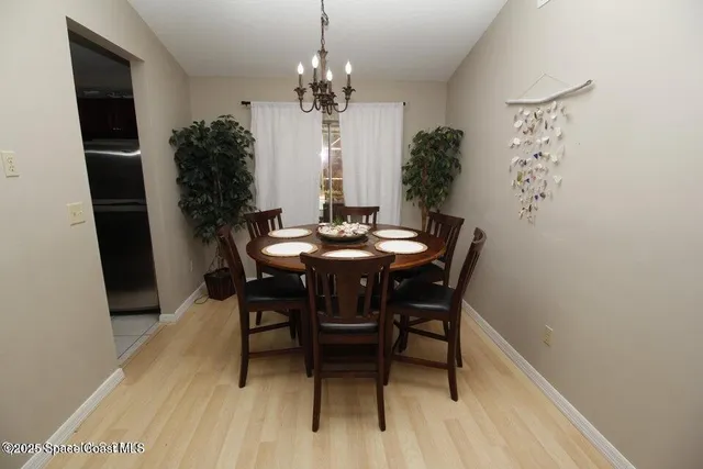 a dining room with furniture potted plants and wooden floor