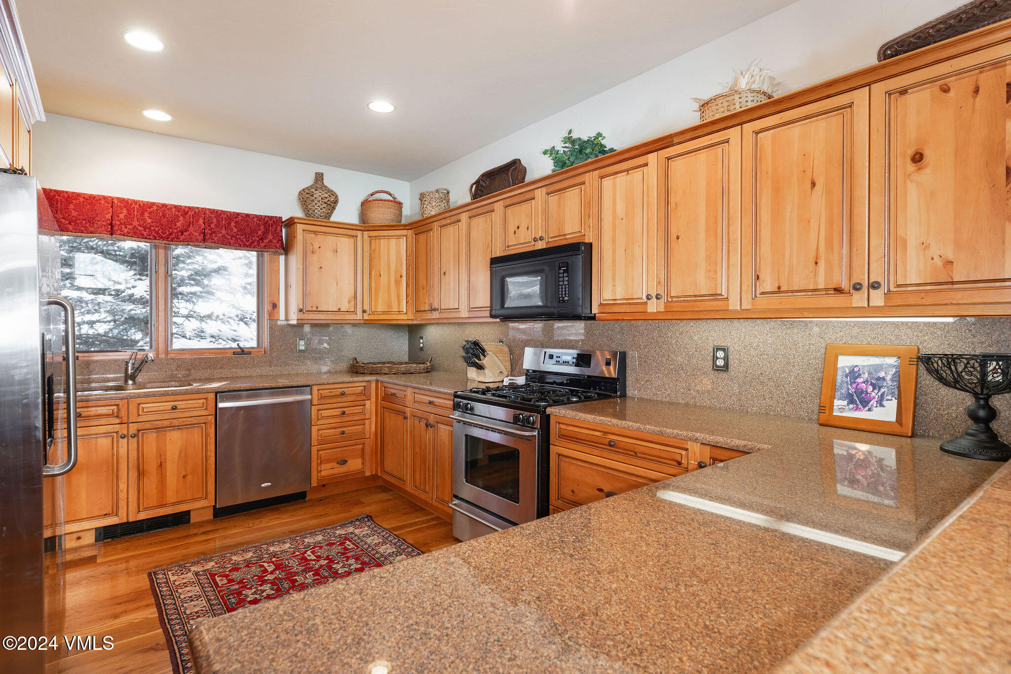 42 Knudson Ranch Road Edwards, CO 81632 - Photo 4 of 22 a kitchen with stainless steel appliances granite countertop a stove top oven a sink dishwasher and a microwave with wooden floor
