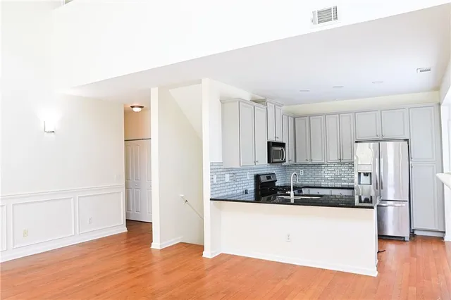 a kitchen with stainless steel appliances a refrigerator sink and microwave