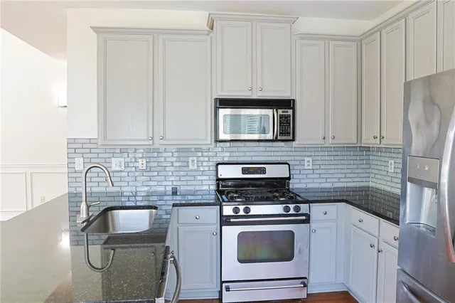 a kitchen with appliances a sink and cabinets