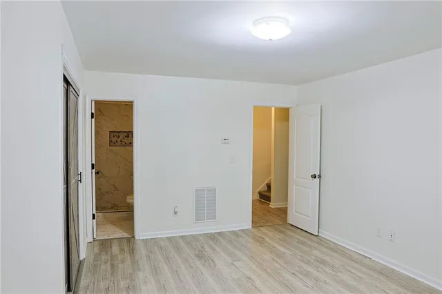 an empty room with closet and wooden floor