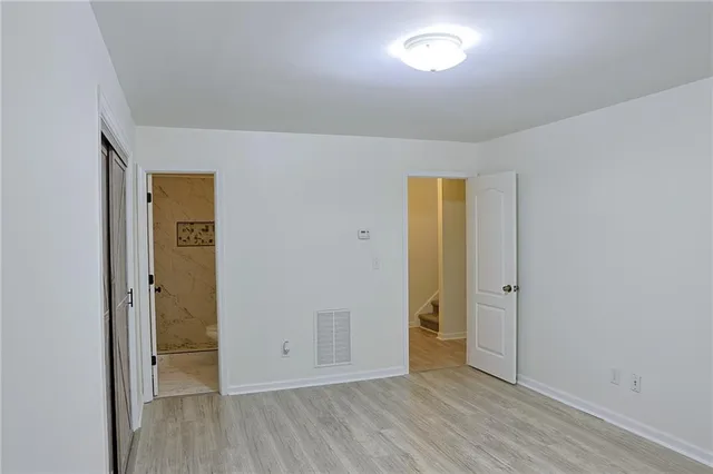 an empty room with closet and wooden floor