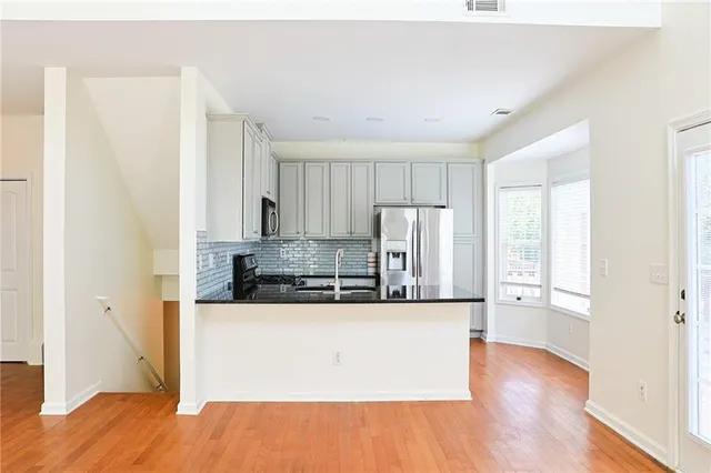 a view of a kitchen with wooden floor and electronic appliances