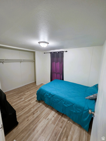 1604 180 East Tooele, UT 84074 - Photo 11 of 16 Second Bedroom featuring wood-finish flooring, a double-rod closet, white walls, and a ceiling-mounted light fixture