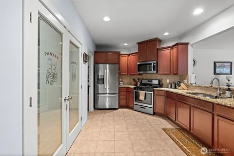 a kitchen with granite countertop stainless steel appliances and wooden cabinets