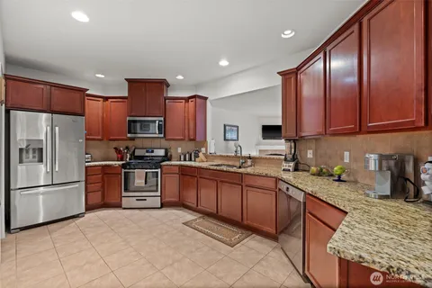 a kitchen with stainless steel appliances granite countertop a sink stove and cabinets