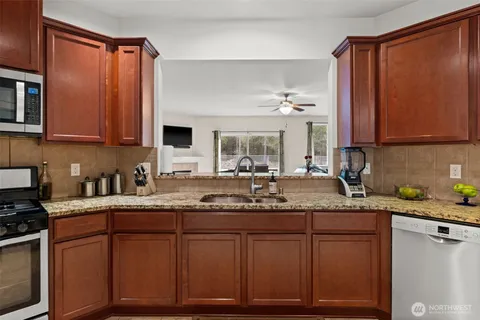 a kitchen with stainless steel appliances granite countertop a stove a sink and a refrigerator