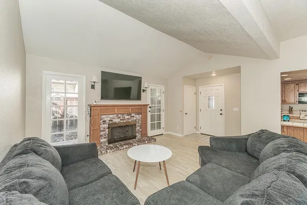 a living room with furniture a fireplace and a flat screen tv