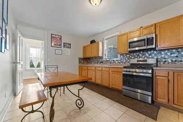 a kitchen with stainless steel appliances kitchen island granite countertop a stove a sink and a microwave