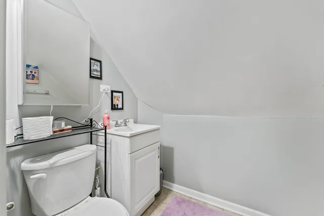 a bathroom with a toilet sink vanity and mirror