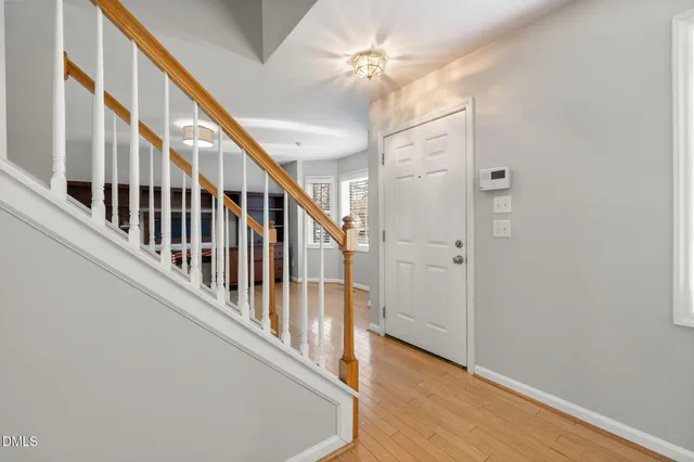 a view of an empty room with window and stairs