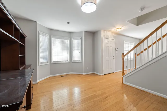 a living room with stainless steel appliances furniture and mirror
