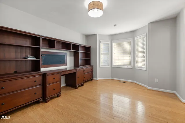 a view of an empty room with a fireplace and wooden floor