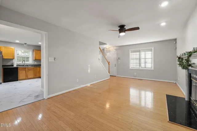 a view of an empty room with a window and fireplace