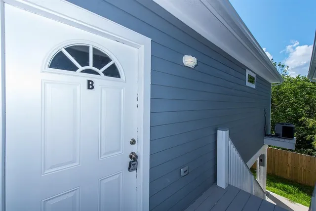 a living room with stainless steel appliances furniture and a view of kitchen