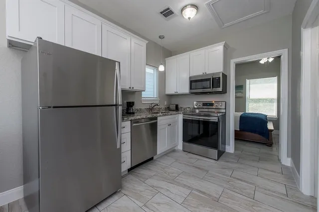 a bathroom with a granite countertop sink mirror vanity and toilet
