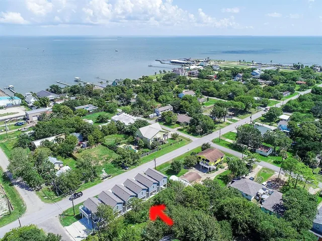 a view of a brick house with large windows and plants