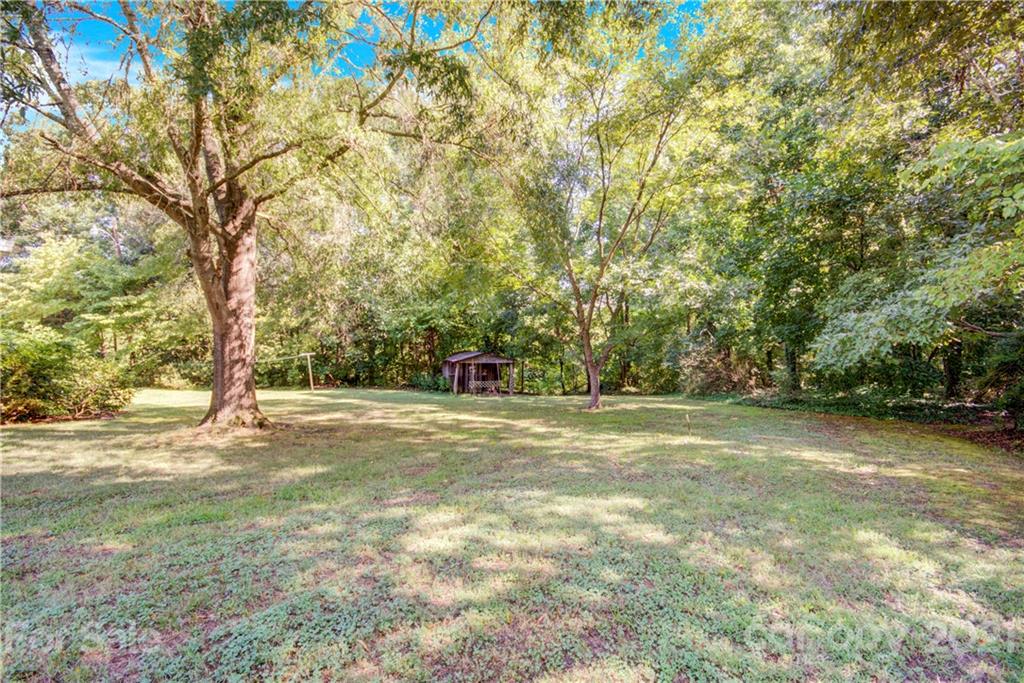 145 Azalea Road Mooresville, NC 28115 - Photo 8 of 24 a view of a field with trees in front of it