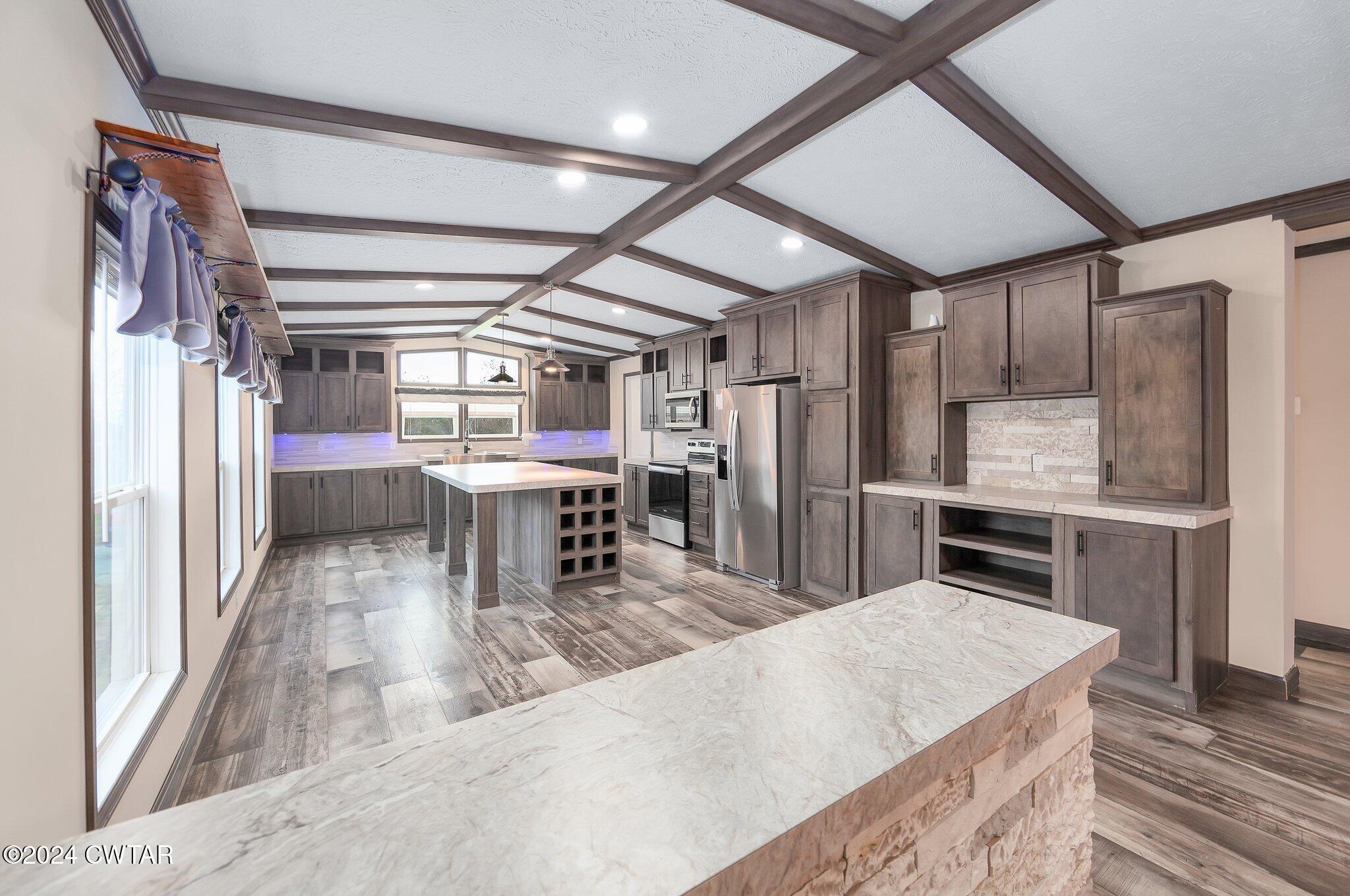 386 Bond Cemetery Road Denmark, TN 38391 - Photo 6 of 40 a kitchen with stainless steel appliances kitchen island granite countertop a table chairs in it and wooden floors