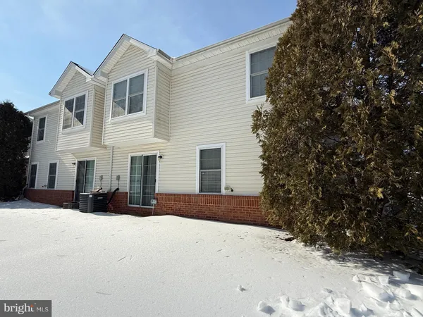 a view of a house with a yard covered in snow