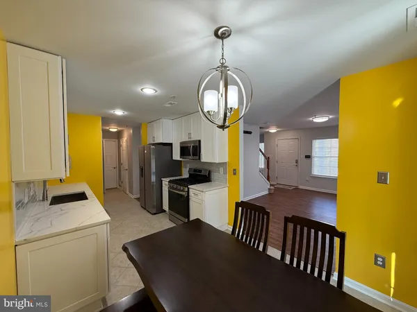 a view of a dining room with furniture a livingroom and chandelier