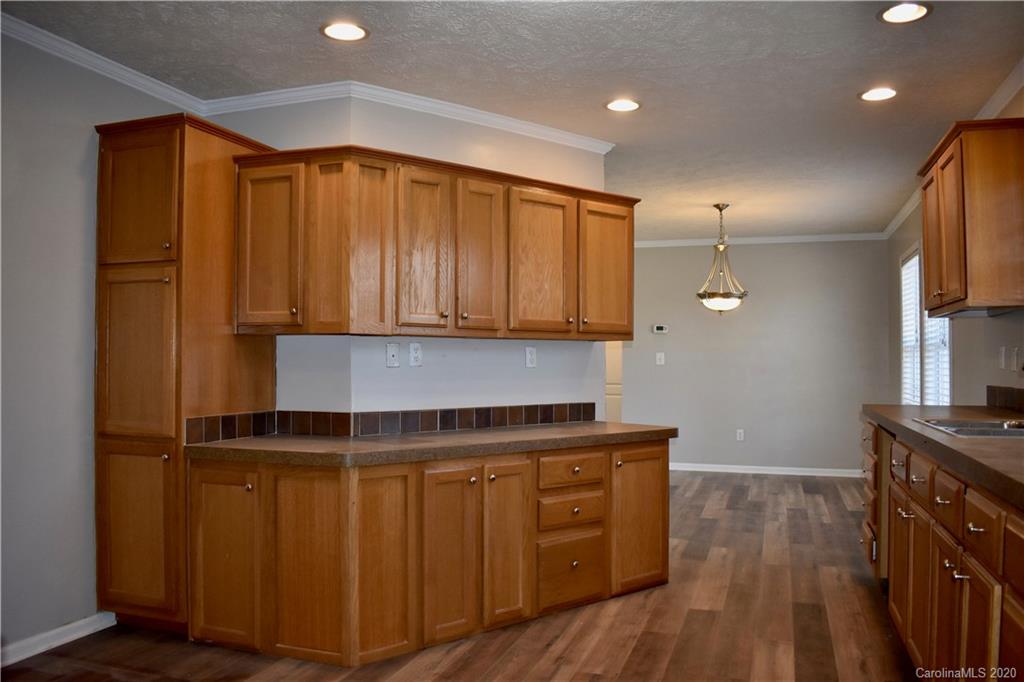 498 Ted Smith Road Rutherfordton, NC 28139 - Photo 17 of 38 a kitchen with wooden floors and wooden cabinets